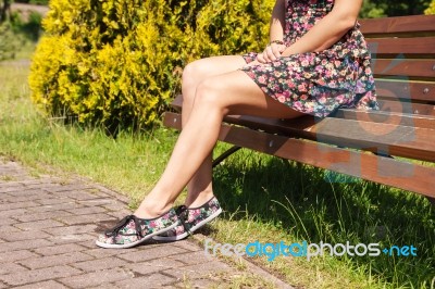 Woman Sitting On A Park Bench Stock Photo