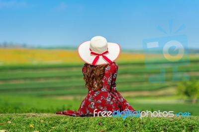 Woman Sitting On Green Grass In Green Tea Field Stock Photo