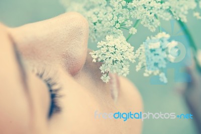 Woman Smelling White Flower Stock Photo