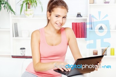 Woman Smiling While Working On Laptop Stock Photo