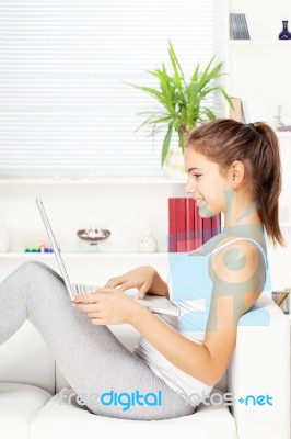 Woman Smiling While Working On Laptop Stock Photo