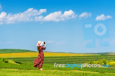 Woman Standing On Green Grass In Green Tea Field Stock Photo