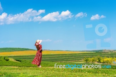 Woman Standing On Green Grass In Green Tea Field Stock Photo