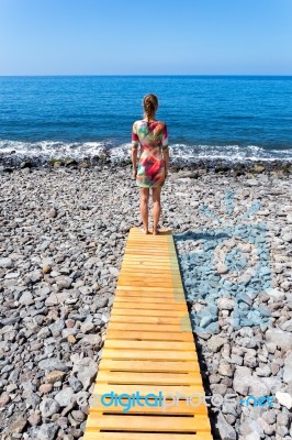 Woman Standing On Wooden Path At  Sea Stock Photo