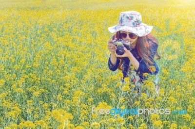 Woman Taking Photos At A Rapeseed Flowers. Vintage Tone Style Stock Photo