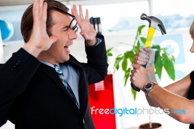 Woman Threatening Her Boss, Holding Hammer Stock Photo