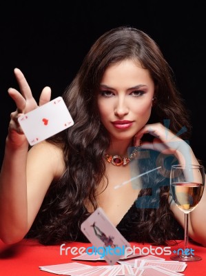 Woman Throwing Gambling Cards On Red Table Stock Photo