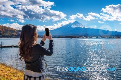 Woman Use Mobile Phone Take A Photo At Fuji Mountains, Kawaguchiko Lake In Japan Stock Photo