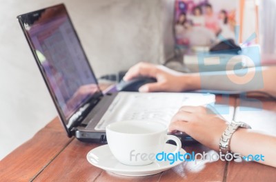 Woman Using Laptop With A Cup Of Coffee Stock Photo