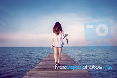 Woman Walking On Wooden Bridge Extended Into The Sea. (vintage Color) Stock Photo