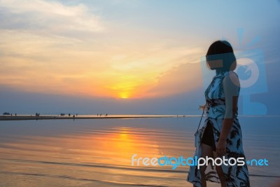 Woman Watching Sunset At The Beach Stock Photo