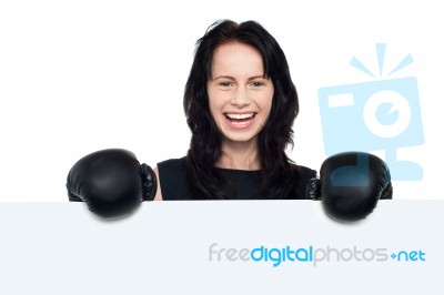 Woman With Boxing Gloves On Posing Behind Billboard Stock Photo