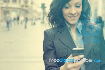 Woman With Cellphone Walking On Street Stock Photo