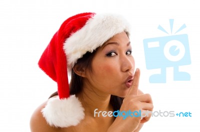 Woman With Christmas Hat And Gesturing To Keep Silent Stock Photo