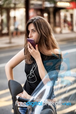 Woman With Smartphone On Motorbike Stock Photo