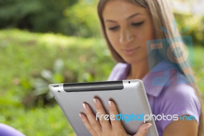 Woman With Tablet Computer In Park Stock Photo