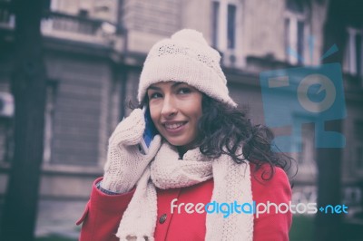 Woman With Wool Cap And Gloves With Smartphone In Hands Going Th… Stock Photo