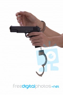 Woman's Hand With Handcuffs And Gun On A White Background Stock Photo