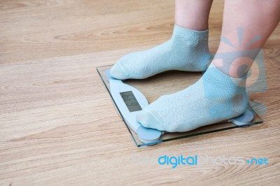 Woman's Legs Standing On The Scales Stock Photo