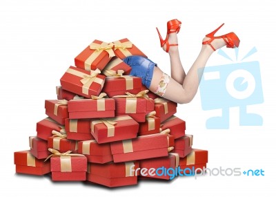 Woman's Legs Sticking Out From A Pile Of Gifts Stock Photo