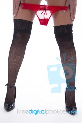 Woman's Legs With Fishnet Stockings And Red Slip Stock Photo