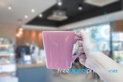 Women Hand Holding Mug With Blurred Cafe Stock Photo