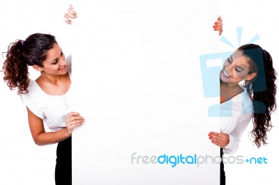 Women Smiling Behind White Board Stock Photo