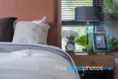 Wooden Bed With Black Lamp On Wooden Table Stock Photo