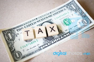 Wooden Block Word Tax And Dollar Banknote Stock Photo