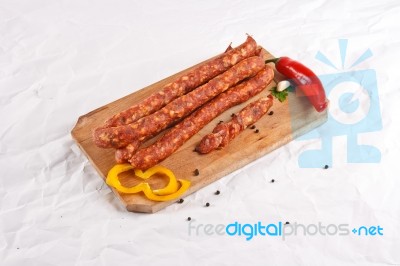 Wooden Chopping Board With Sausages And Spices Stock Photo