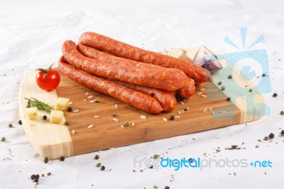 Wooden Chopping Board With Sausages And Spices Stock Photo