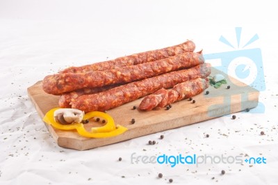 Wooden Chopping Board With Sausages And Spices Stock Photo