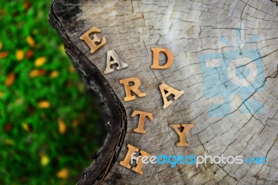 Wooden Earth Day Word On Wood Log Background. Help Protect Our Trees Idea Stock Photo