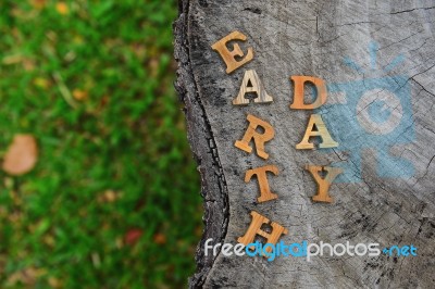 Wooden Earth Day Word On Wood Log Background. Save The Earth Idea Stock Photo