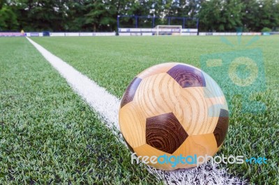 Wooden Football Lying On Sideline On Football Field Stock Photo