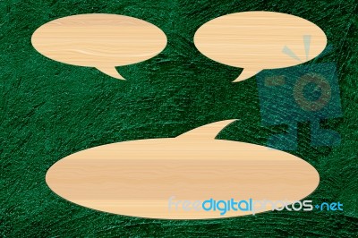 Wooden Speech Bubble On Green Cement Background Stock Image