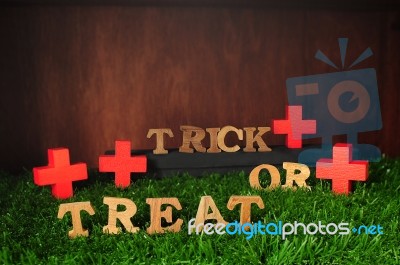 Wooden Trick Or Treat Words And Wooden Cross On Grass Background… Stock Photo