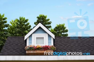 Wooden Window With Flower At The Roof Of The House Stock Photo