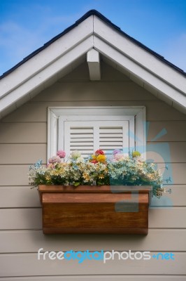 Wooden Window With Flower At The Roof Of The House Stock Photo