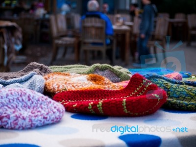 Wooly Beanies On A Table With People In The Background Stock Photo