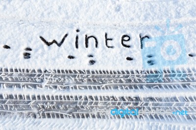 Word Winter And Tire Tracks In Snow Stock Photo