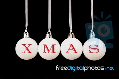 Word Xmas On White Christmas Balls Hanging On Black Background Stock Photo