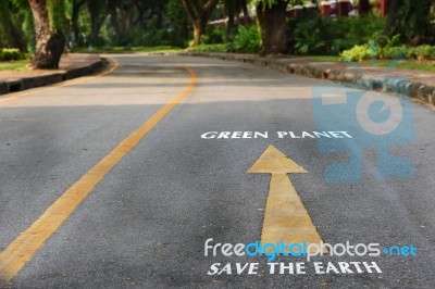 Words Of Save The Earth And Green Planet On The Road Surface Stock Photo