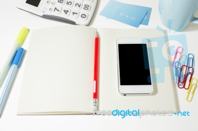 Work Table With Blank Notebook And Phone Stock Photo