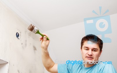 Worker Painting Wall With Background Glue For A Wallpaper Stock Photo