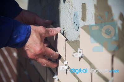 Worker Puts The Ceramic Tiles On The Wall Stock Photo