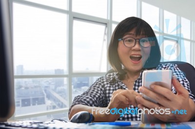 Working Woman Looking To Smart Phone With Amazing Happiness Face In Working Office Room Stock Photo