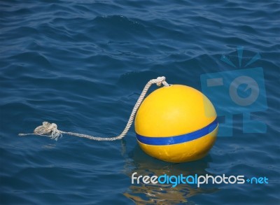 Yellow Buoy Floating On Blue Sea Stock Photo