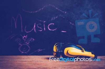 Yellow Headphones On Wooden Background Stock Photo