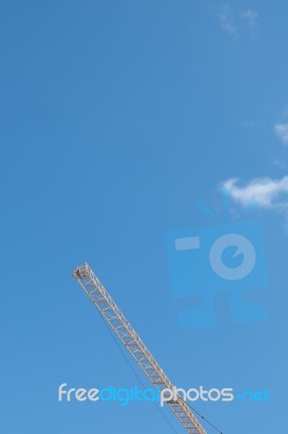 Yellow High Long Crane Arrow At Construction Site With Clear Light Blue Sky Day Stock Photo